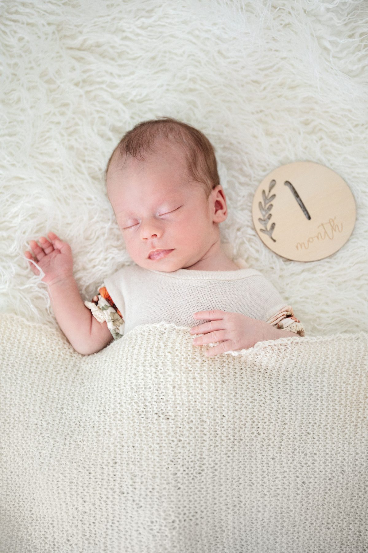 Baby mit Holzschild 1 Monat