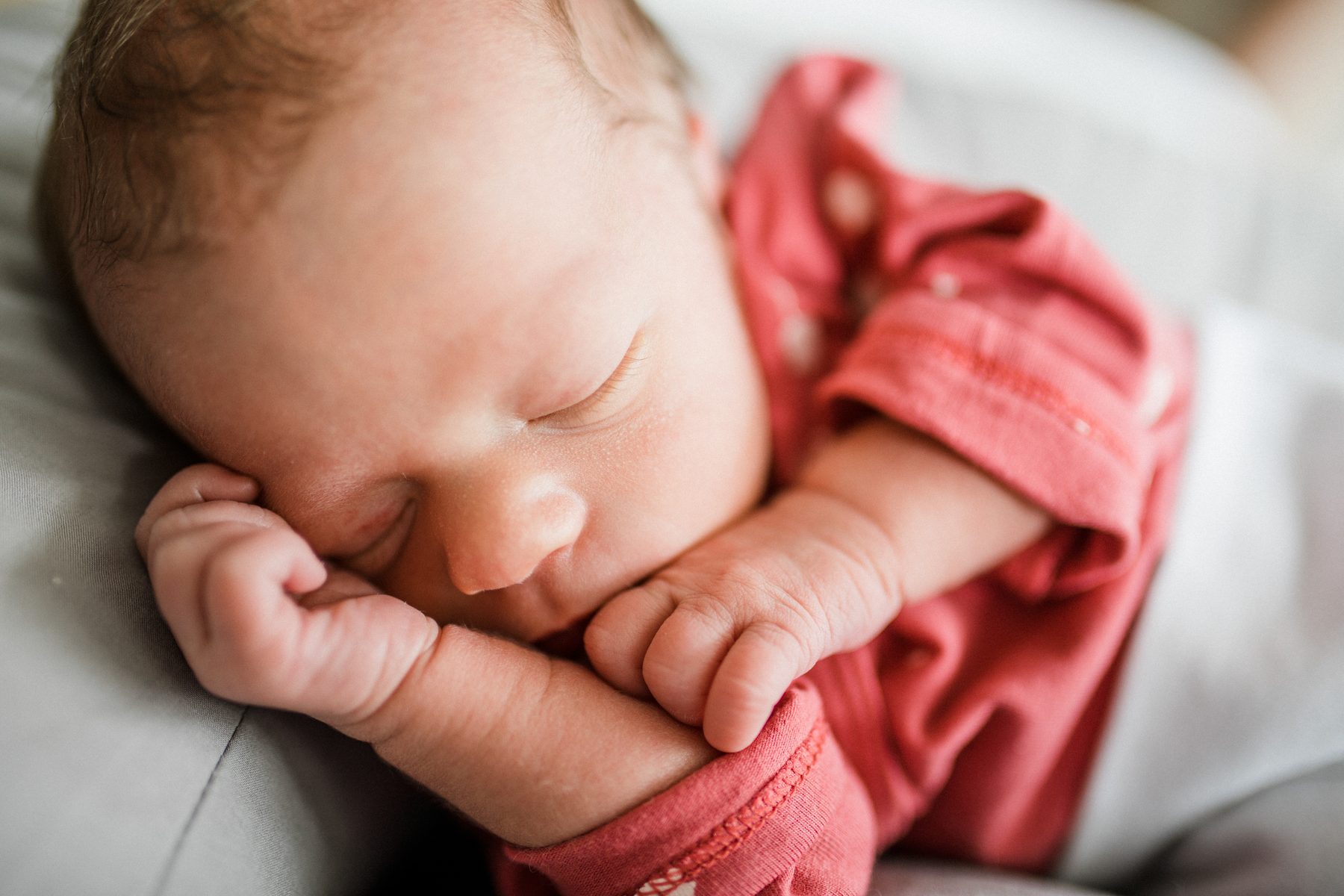 Schlafendes Baby in rosa Body